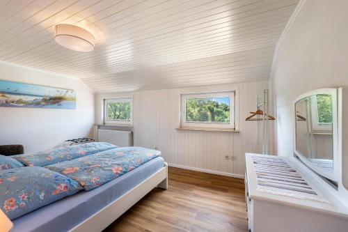 a bedroom with a bed and two windows at Park – House in Oldenburg in Holstein
