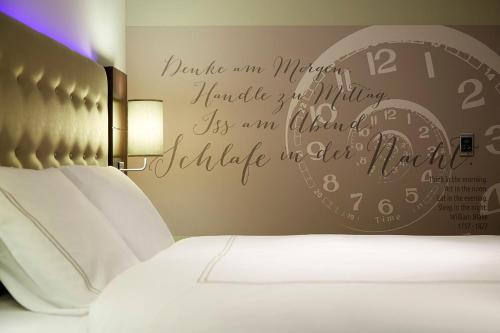a bedroom with a bed with a clock on the wall at Premier Inn Hamburg City Berliner Tor in Hamburg