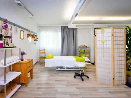 a bedroom with a white bed and a yellow blanket at Ibis Styles Linz in Linz
