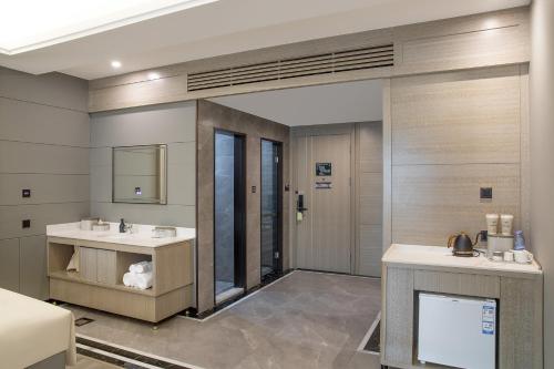 a bathroom with two sinks and a mirror at Atour Hotel Hotan Unity Plaza in Hoten