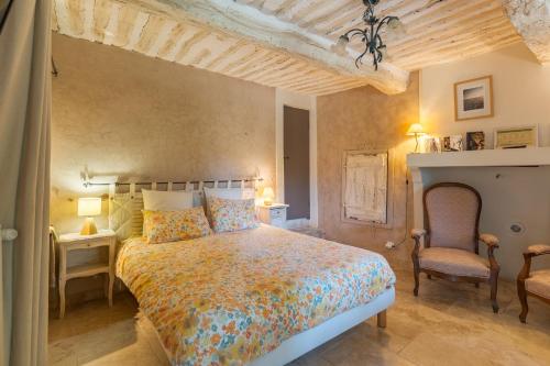a bedroom with a large bed and two chairs at Ma Maison De Loin - Luberon in Apt