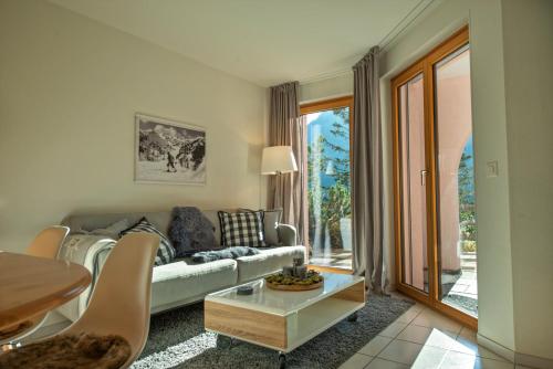 a living room with a couch and a table at Haus Belvédère in Arosa
