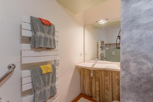 a bathroom with a sink and a mirror and towels at Ma Maison De Loin - Luberon in Apt