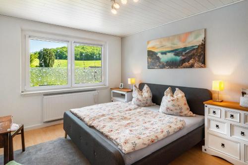 a bedroom with a bed and two windows at Ferienwohnung am Herreder Wald in Nordhausen