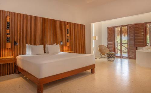 a bedroom with a large white bed in a room at Villas HM Paraiso del Mar in Holbox Island