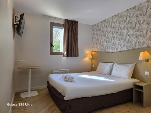 a hotel room with a bed and a window at Kyriad Chantilly in Chantilly