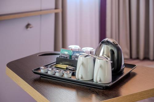 a tray with a tea kettle and cups on a table at Premier Inn Stuttgart Zuffenhausen in Stuttgart