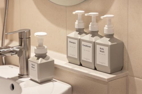 four bottles ofodorizers sitting on a shelf in a bathroom at 한옥스테이 화랑루 in Gyeongju