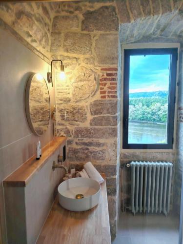 a stone bathroom with a sink and a window at Château Hôtel La Terrasse - Teritoria in Meyronne