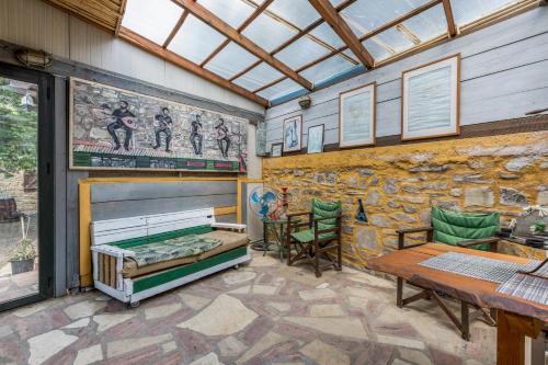 a room with a stone wall with a bed and a table at Akros Oreon, Omalos Studio in Káto Sími