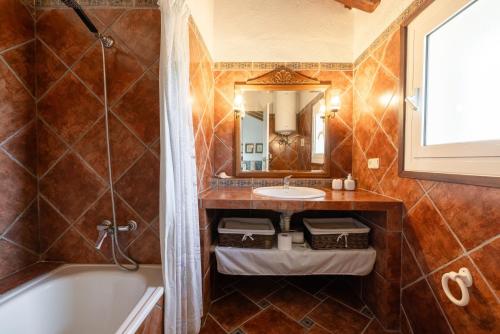 a bathroom with a tub and a sink at Casa Sorrapa in Deltebre