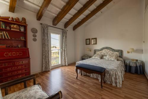 a bedroom with a bed and a dresser and a window at Casa Sorrapa in Deltebre