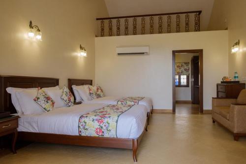 a bedroom with a large bed and a chair at Summer Vines - Nashik in Pandhurli