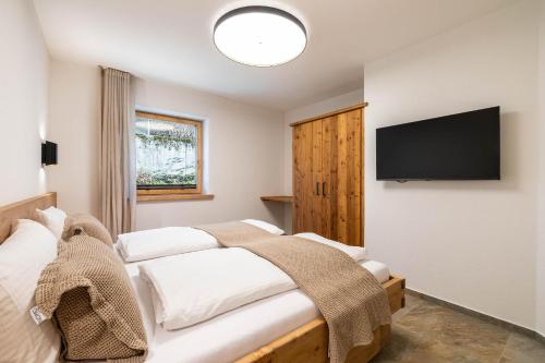 a bedroom with a bed and a flat screen tv at Appartementhaus Moritz in Reith bei Seefeld