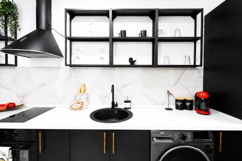 a black and white kitchen with a sink at Occo by the Pool in Popeşti-Leordeni