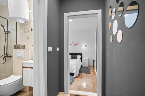 a bathroom with a bedroom with a bed and a mirror at Apartment & Rooms - Marina in Ploče