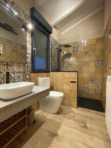 a bathroom with a sink and a toilet and a shower at Casa Los Tres Panetes Béjar in Béjar
