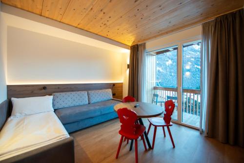 a bedroom with a bed and a table and chairs at mySHH Smart in Vigo di Fassa