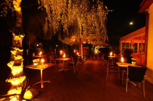 a deck with tables and chairs with candles on them at Landhaus Gut Halte in Papenburg