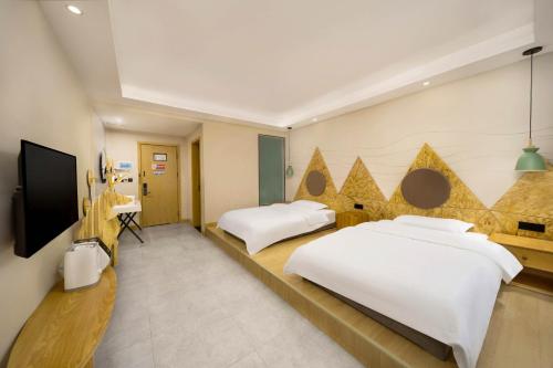 a hotel room with two beds and a flat screen tv at Jianshanxi Designer Hotel in Mount Siguniang