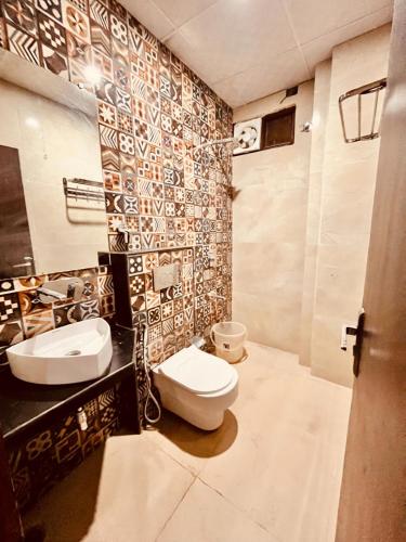 a bathroom with two sinks and a toilet in it at Hotel Ramawati Near Ganga Ghat, Haridwar in Haridwār