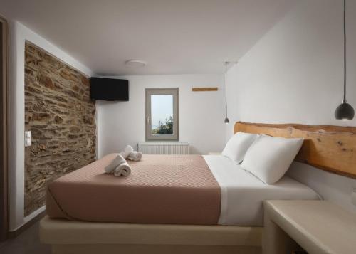 a bedroom with a bed with a teddy bear on it at Falcon Eyes- Panoramic stone house in Andros