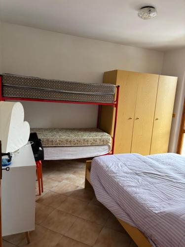 a bedroom with two bunk beds and a bed at Claudia F in Pievepelago