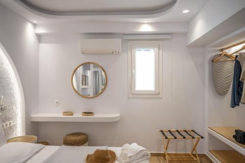 a white room with a bed and a mirror at Valetta Inn in Naxos Chora