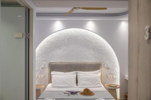 a bedroom with a bed with a large head board at Valetta Inn in Naxos Chora