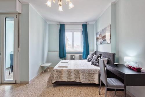 a bedroom with a bed and a desk and a window at Ca Teresa 14 in Marghera