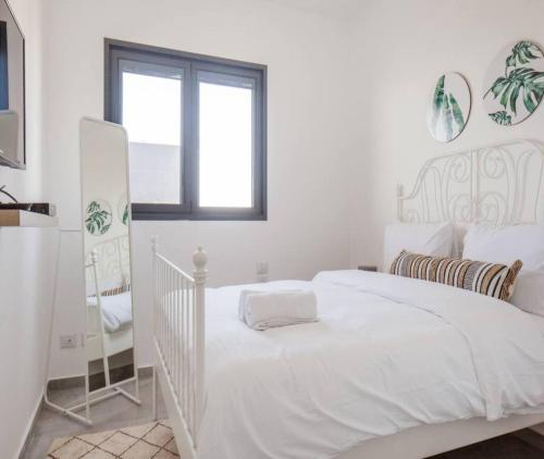 a white bedroom with a white bed and a window at Magical 4BR APT With Panoramic Sea View l Mamad in Bat Yam