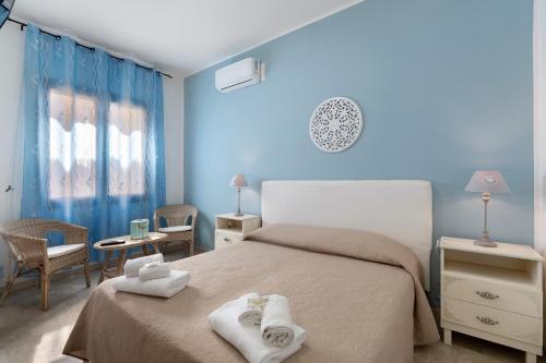 a blue bedroom with a bed with towels on it at Demetra Malophoros in Marinella di Selinunte