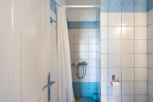 a bathroom with a shower with a white shower curtain at Driopida 5 Irida Kythnos in Mérikhas