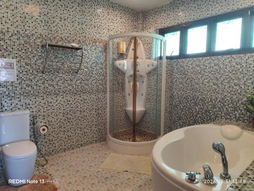 a bathroom with a shower and a tub and a toilet at Baan Dorkbua Villa in Bophut