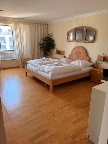 a bedroom with a large bed and a wooden floor at Marina 38-2 in Cuxhaven