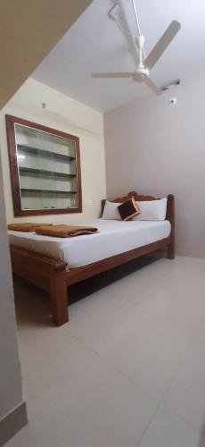 a bedroom with a large bed with a window at SRM Residency in Alāndurai