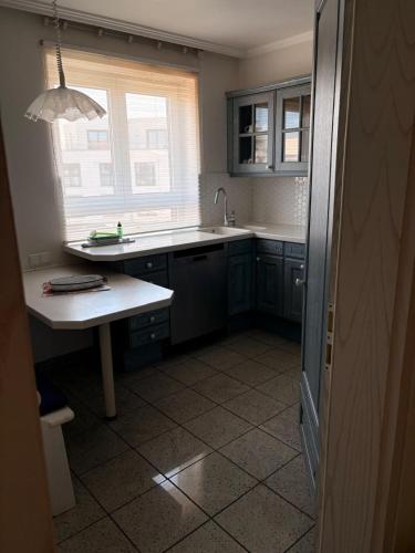 a kitchen with blue cabinets and a sink and a window at Marina 38-2 in Cuxhaven