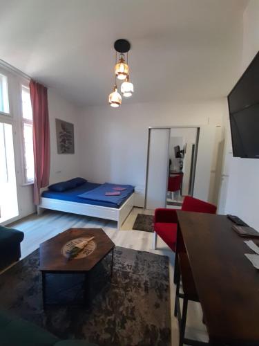 a living room with a bed and a table at FG Apartment in Sarajevo