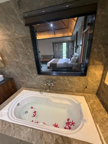 a bathroom with a bath tub with a large mirror at Jawai's Wildness Lodge in Bera