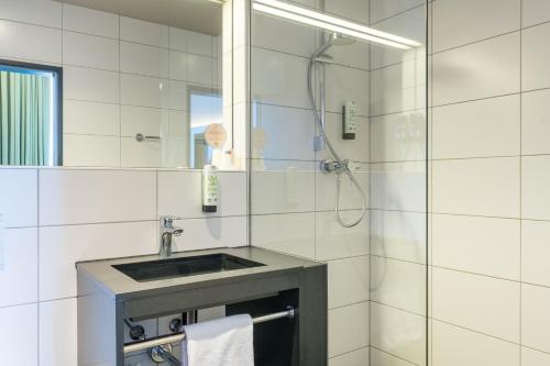 a bathroom with a sink and a shower at JOESEPP´S HOTEL am Schweizerberg in Memmingen