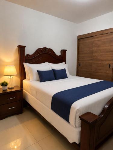a bedroom with a large bed with blue and white pillows at Modern Cozy apartment in Boca Chica