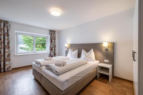 a bedroom with a large bed and a window at Schwarzhans Appartments in Bludenz