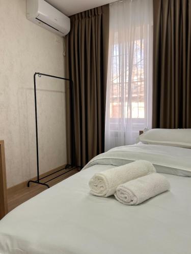 a hotel room with two beds with towels on them at Three rooms on Arbat in Shymkent