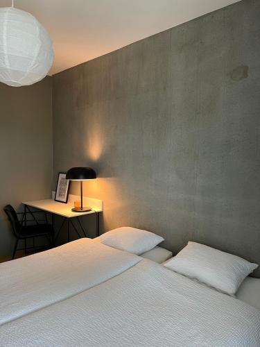 a bedroom with two beds and a desk with a lamp at Tikka Apartments in Jyväskylä