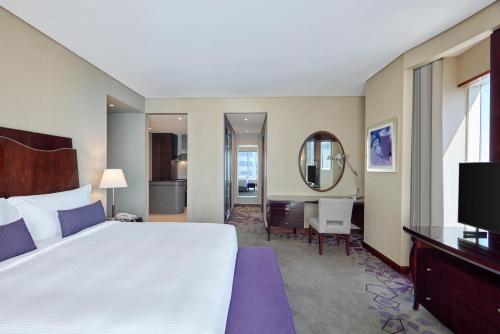a hotel room with a large bed and a television at Rose Rayhaan by Rotana - Dubai in Dubai