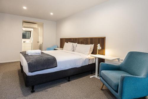 a bedroom with a bed and a blue chair at Alpine Chalets in National Park