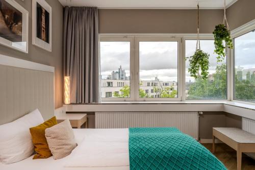 a bedroom with a bed and two windows at The Blasky in Frankfurt