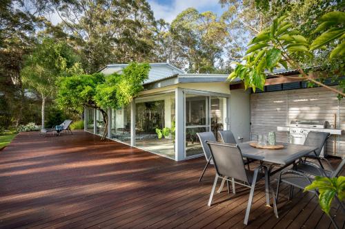 a deck with a table and chairs on a house at Emerald Cove I Private Properties in Denmark