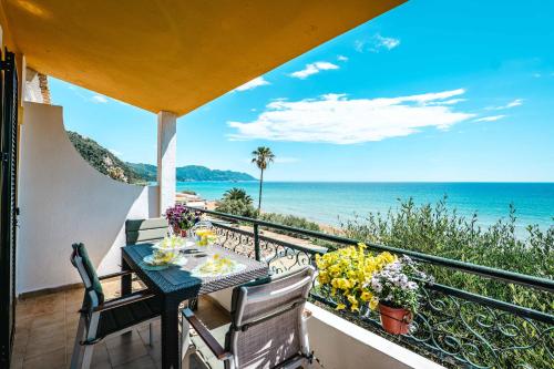 a balcony with a table and chairs and the ocean at Corfu Glyfada Beach Apartment 25 in Glyfada