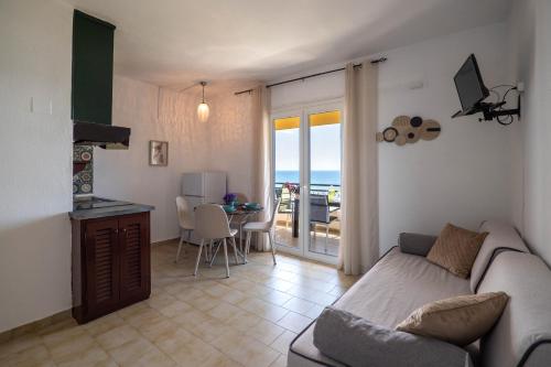a living room with a couch and a table with a balcony at Corfu Glyfada Beach Apartment 25 in Glyfada